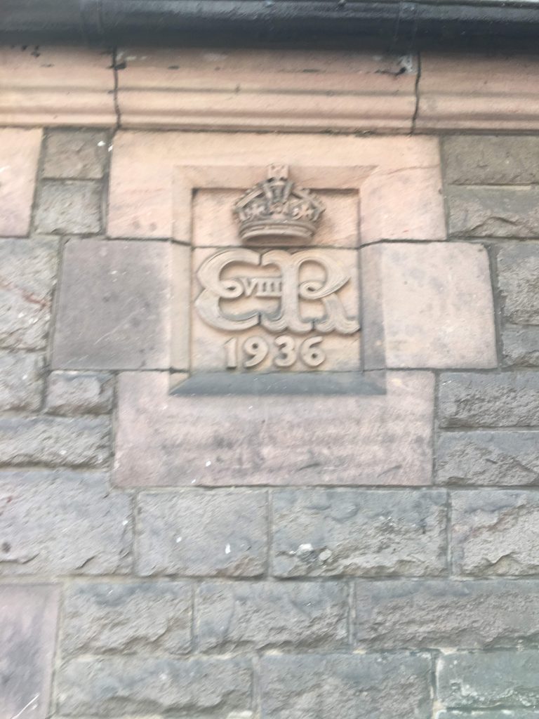 Detail of brick building with carving ER 1936 surmounted by a crown and VIII between the letters. 